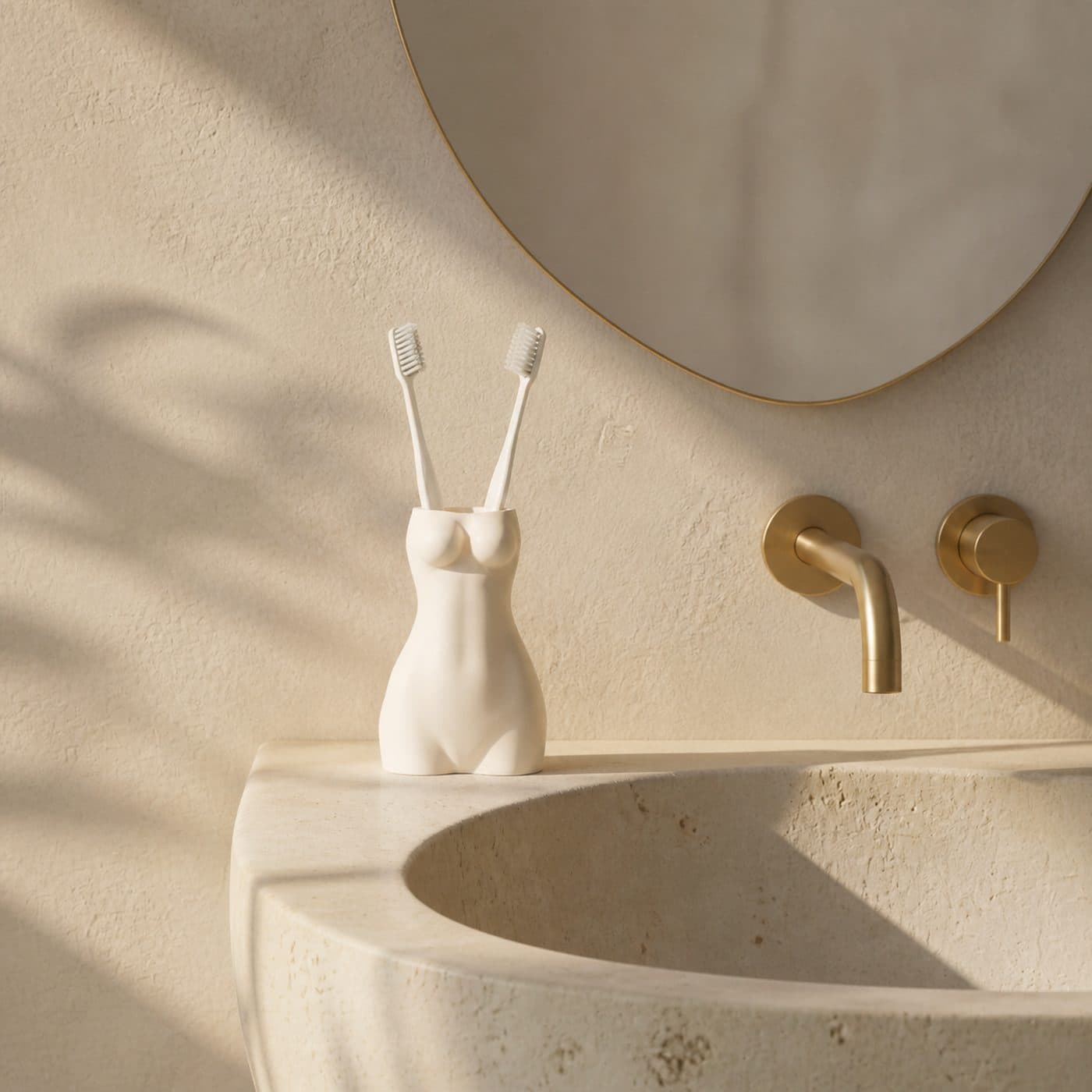 Porte-brosse à dents design La Favorite blanc sur une vasque en travertin, robinetterie et miroir rond en laiton