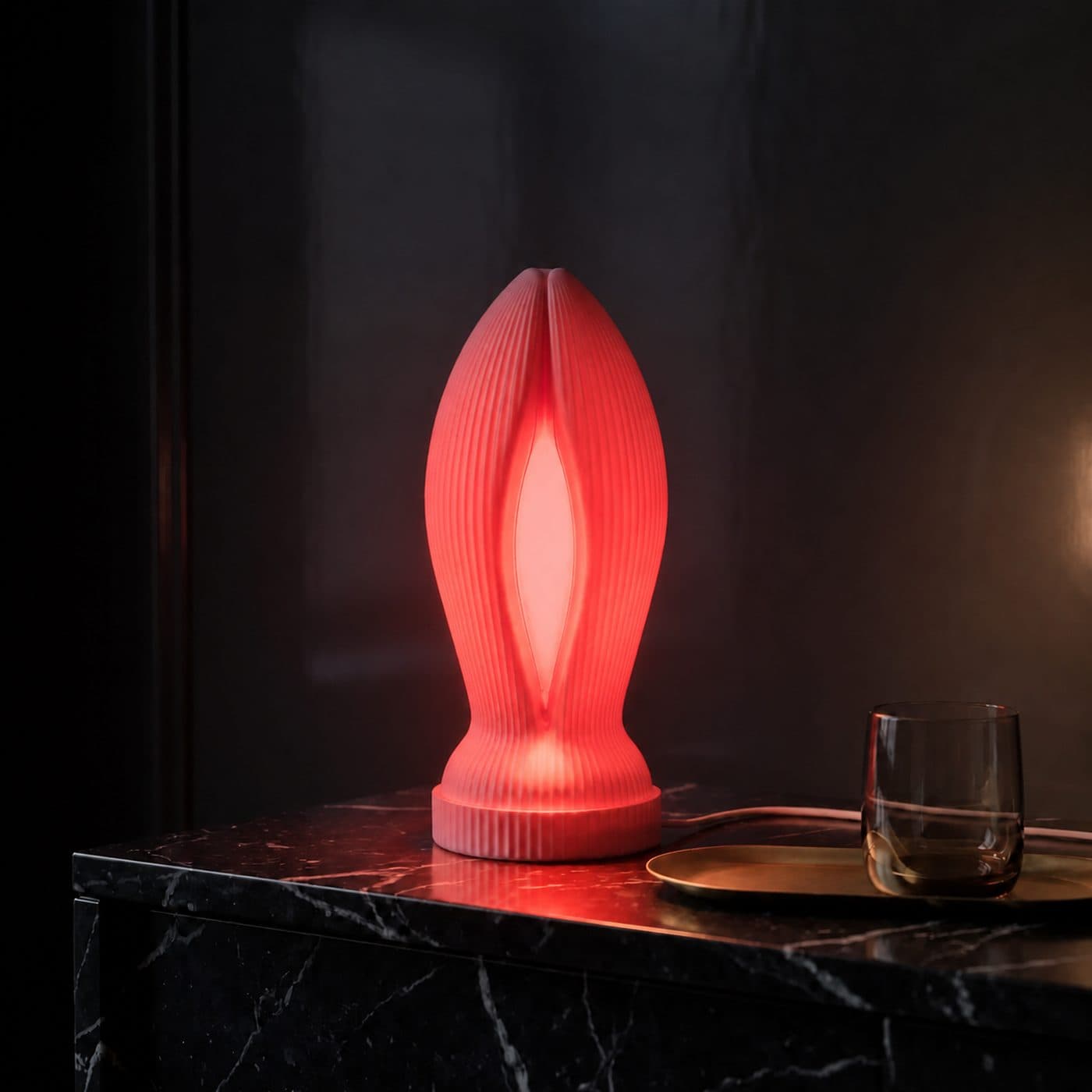 Cadeau insolite Lampe Madame allumée sur une console en marbre noir, plateau de laiton et verre